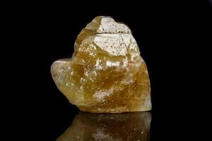 Macro mineral stone yellow Calcite on a black background photo