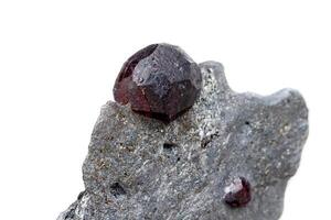 Macro mineral stone garnet in the rock on a white background photo