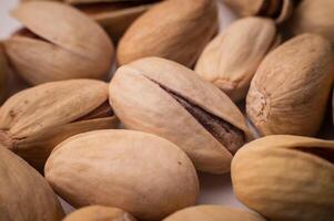 Many closed pistachios in macro close-up. Healthy food background with selective soft focus photo