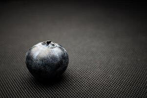 One blueberry black background. Very detailed macro shoot with copy space photo