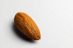 Almonds on a white background, close-up of the seed from the side. One nut macro shot photo