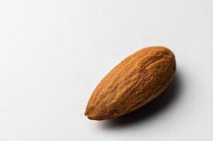 uno amígdala en un blanco antecedentes. Almendras de cerca, textura visible foto