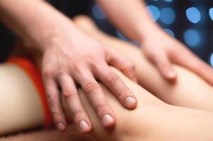 Massage stroking the ankle muscles in a professional office in a shallow depth of field. photo