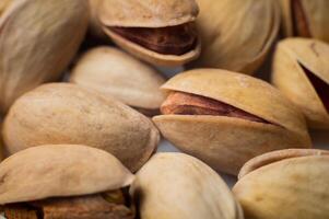 Many closed pistachios in macro close-up. Healthy food background with selective soft focus photo