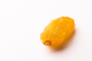 macro photograph of one raisin on a white background, side view photo