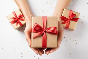 Female hands holding a gift box on a light background, top view photo