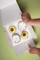 female hands open a box with different cakes dessert home delivery photo