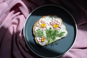 creativo emparedado con suave queso y rosado pasta tarama verduras, flores foto