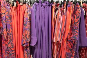 different models orange and purple blouses in the store grouped in the color photo