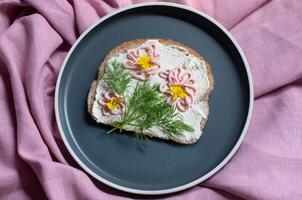 creativo emparedado con suave queso y rosado pasta tarama verduras, flores foto