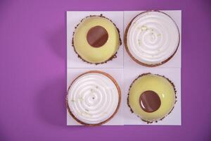 a variety of original cakes top view boxes on a purple background, culinary photo