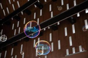 flying multicolored soap bubbles on a background of a roof with rectangular holes exotic background texture photo