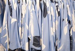 azul y blanco verano blusas en un percha en el almacenar, brillante verano ropa foto