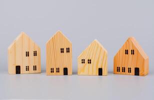 pequeño de madera casa, juguete casa, modelo de madera casa en un ligero verde antecedentes. foto