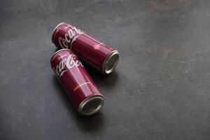 KYIV, UKRAINE - 4 MAY, 2023 Coca cola soft drinks brand tin cans with cherry flavour photo