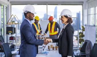African American manager is handshaking with Caucasian female partner for global industrial development project with modern business district skyscraper building background photo