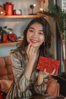 Lovely Chinese teen lady with a Asiatic appearance jolly presenting the cosmetic gifts she received from her faithful sweetheart. The products highlight her lovable femininity photo