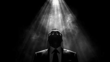 Man in business attire stands in front of bright beam of light photo