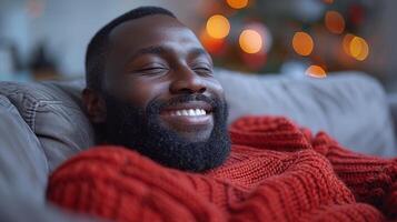 A man wearing a red sweater smiles happily photo