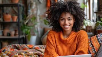 A woman sitting on a couch, working on a laptop photo