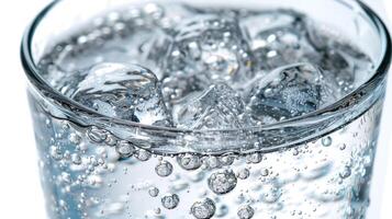 A glass of water with ice cubes melting slowly in it photo