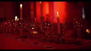 empty wine glasses stand on a decorated table in a red light, a social event video