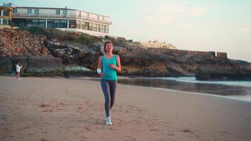 un' donna jogging su il spiaggia vicino il oceano video