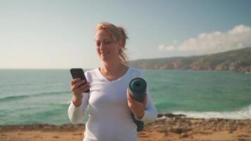 Senior mulher praticando ioga exercício em a de praia. video