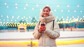a woman in a winter coat standing close to ice rink video