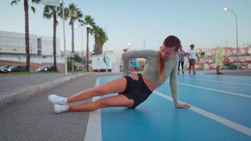 deportivo mujer en corriendo pista haciendo sentadillas ejercicios. video