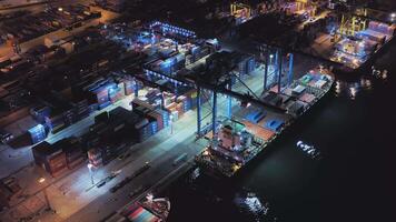 Aerial. container ships are in the port at the quay wall at night video