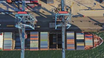 Top down aerial. Containers unloaded by a gantry crane from a container ship video