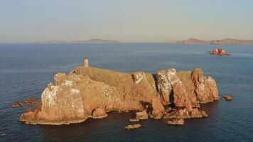 Drone view on abandoned lighthouse on top of a rocky island at sunrise video