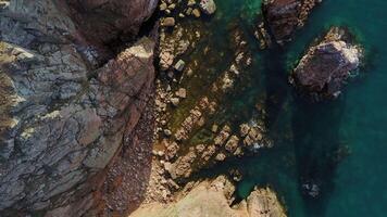 Rocky beach on the sea coast with clear water and beautiful vertical rocks video