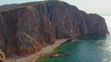 klippig strand på de hav kust med klar vatten och skön vertikal stenar video
