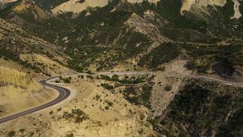 The yellow car is driving down a winding road. Sunny views. Mediterranean video