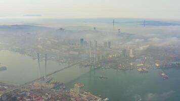 das mystisch Morgen Stadt mit Häuser verhüllt im Nebel. golden Brücke video