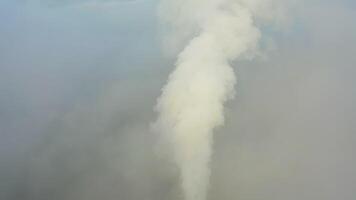 Rauch von ein Leistung Bahnhof Kamin steigend von ein niedrig, kriechend Nebel. Drohne Aussicht video