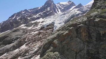 glaciar cubierto con Roca rocas, profundo grietas y pequeño cascadas video