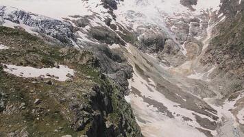 glaciar cubierto con Roca rocas, profundo grietas y pequeño cascadas video