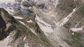 Glacier covered with stone rocks, deep cracks and small waterfalls video