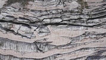 Glacier covered with stone rocks, deep cracks and small waterfalls video