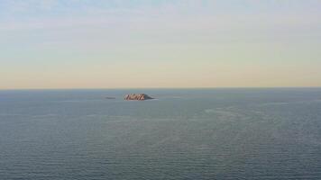 An abandoned lighthouse on top of a rocky island at sunrise video