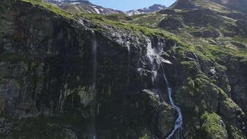 Wasser fließt Nieder das Steigung von ein Berg Tropfen Spritzen von ein enorm Felsen video