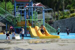 febrero 29, 2024. maglang, Indonesia. juguetón, reír, y disfrutar niños en agua parque foto
