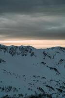 ver de el invierno puesta de sol y cubierto de nieve montañas foto