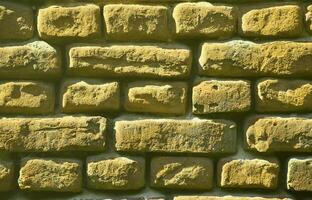 Horizontal wall texture of several rows of very old brickwork made of red brick. Shattered and damaged brick wall with pinched corners photo