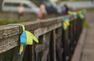 Ribbons in the colors of the national flag of Ukraine are tied to the handrail photo