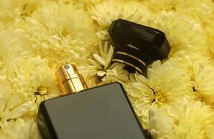 Women fragrance perfume bottle with flowers background close up. Unnamed blank sprayer bottle of perfume photo