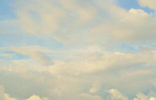 A blue cloudy sky with many small clouds blocking the sun photo